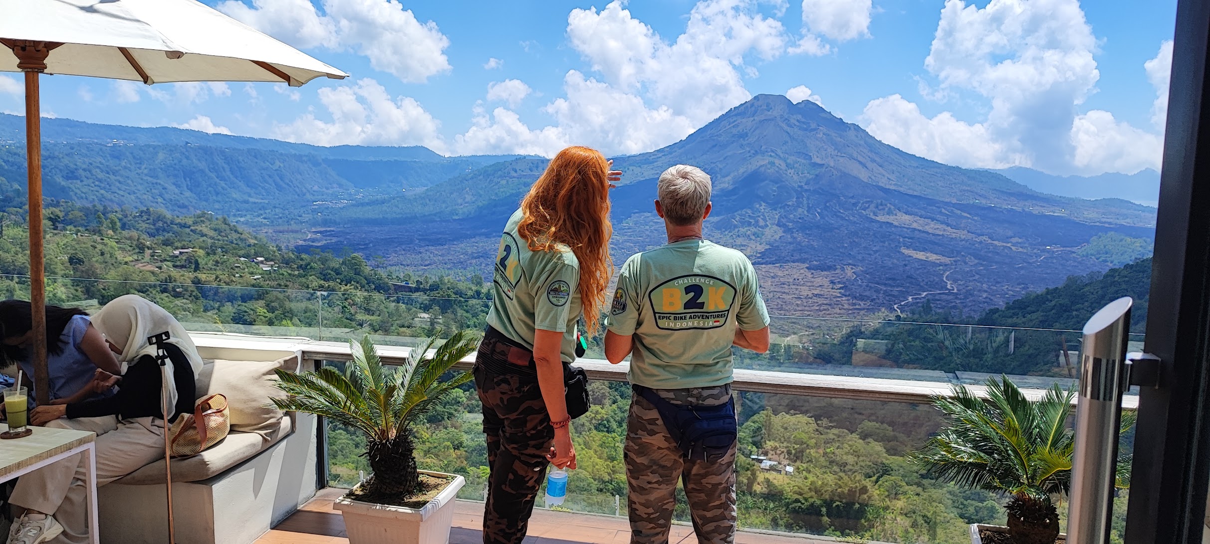 Two riders looking out over Mount Batur from the crater rim