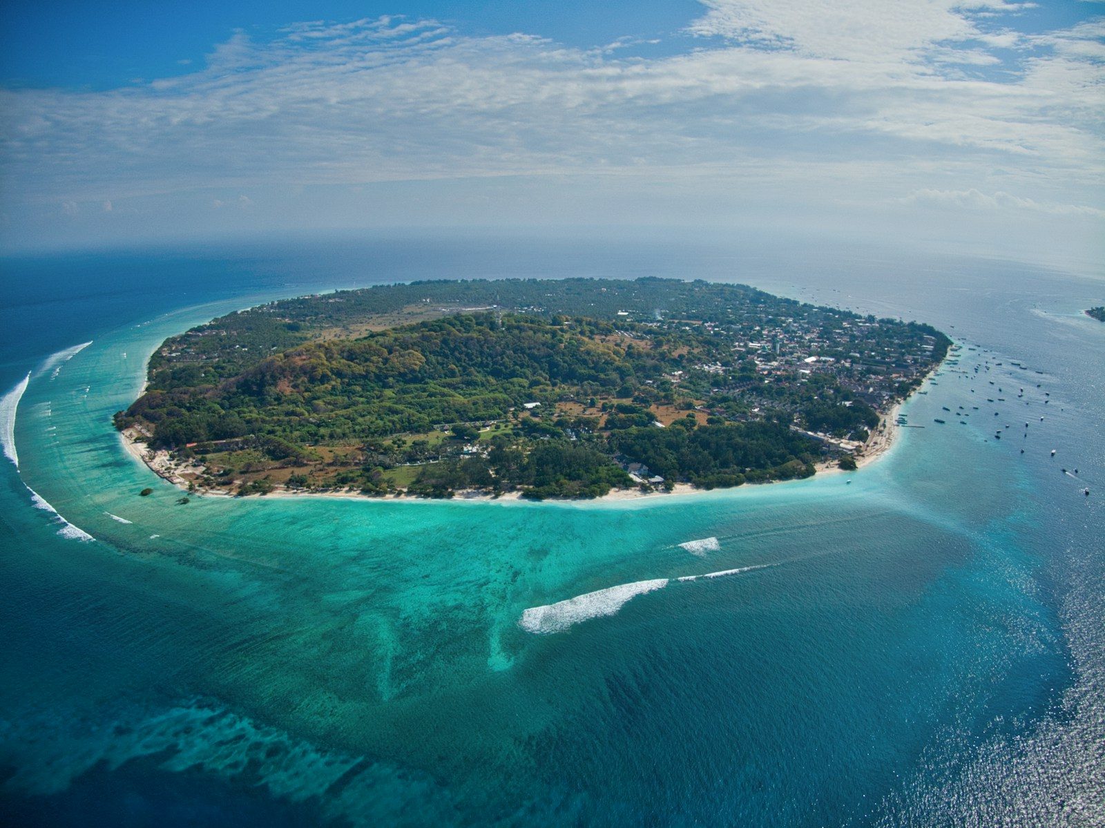 Aerial view of a small island ringed by turquoise reef