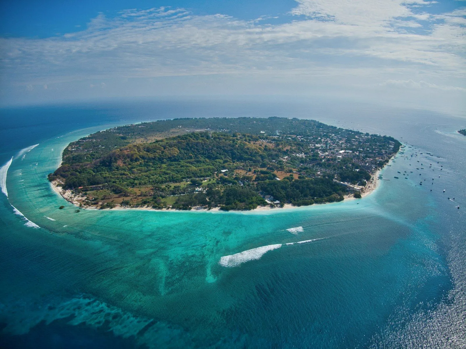 Aerial view of a small island ringed by turquoise reef