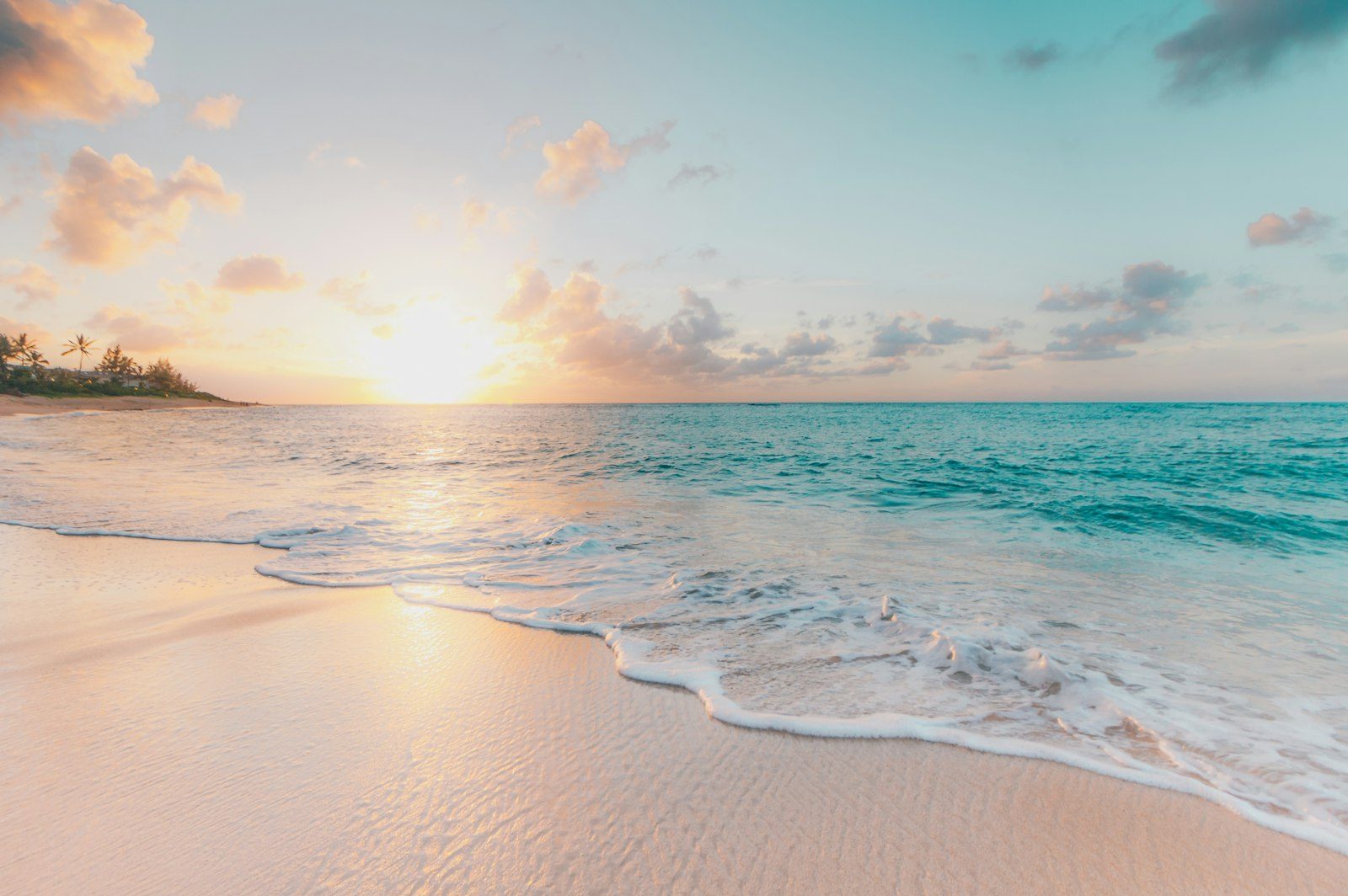 Tropical beach at sunset, gentle surf on pale sand